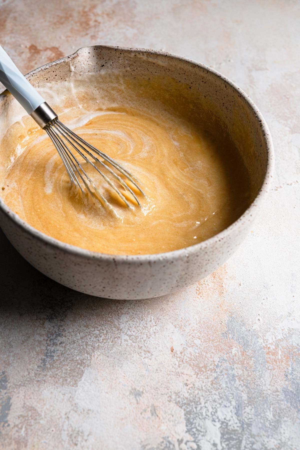 A whisk mixing meringue into a bake batter.