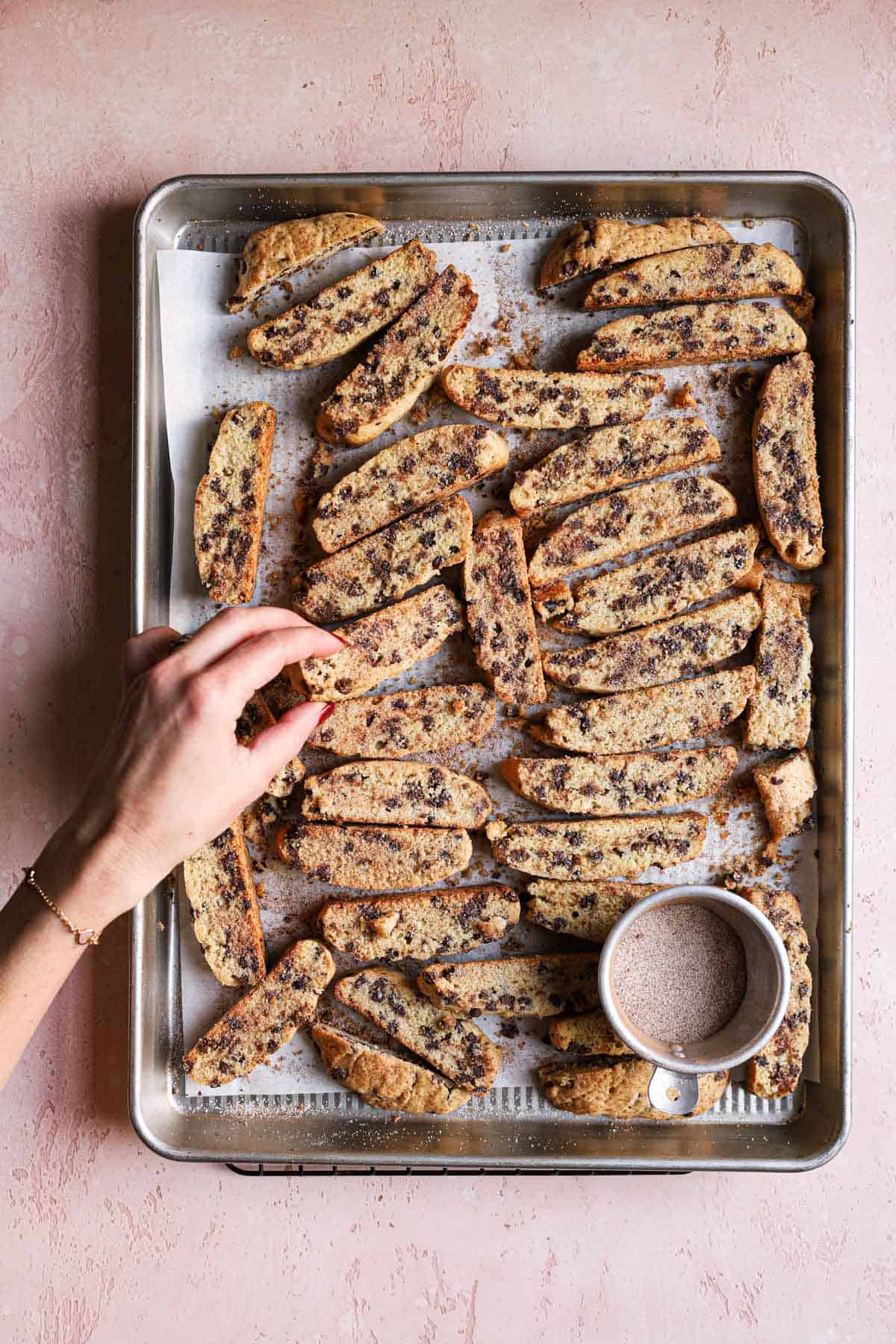 A hand turning over jewish biscotti cookies.
