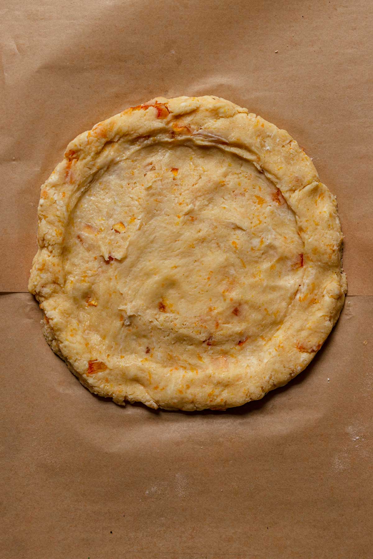 A scone dough on a piece of parchment paper.
