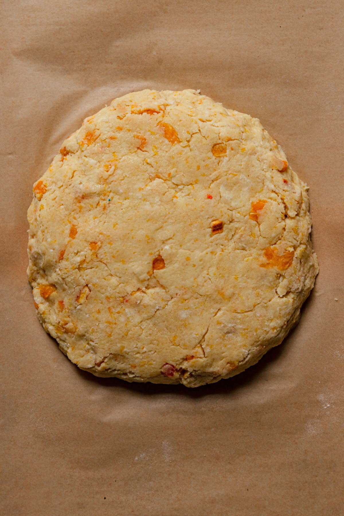 Round unbaked orange scone dough.
