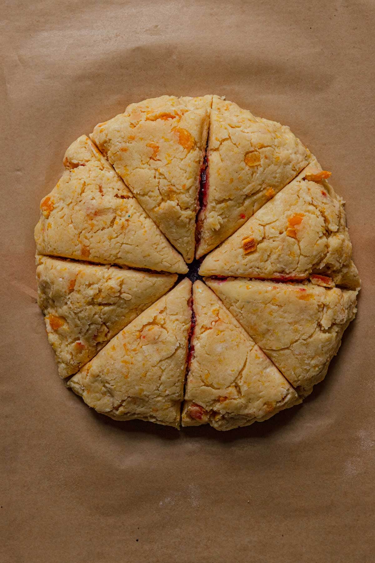 Unbaked scone dough cut into 8 triangles.