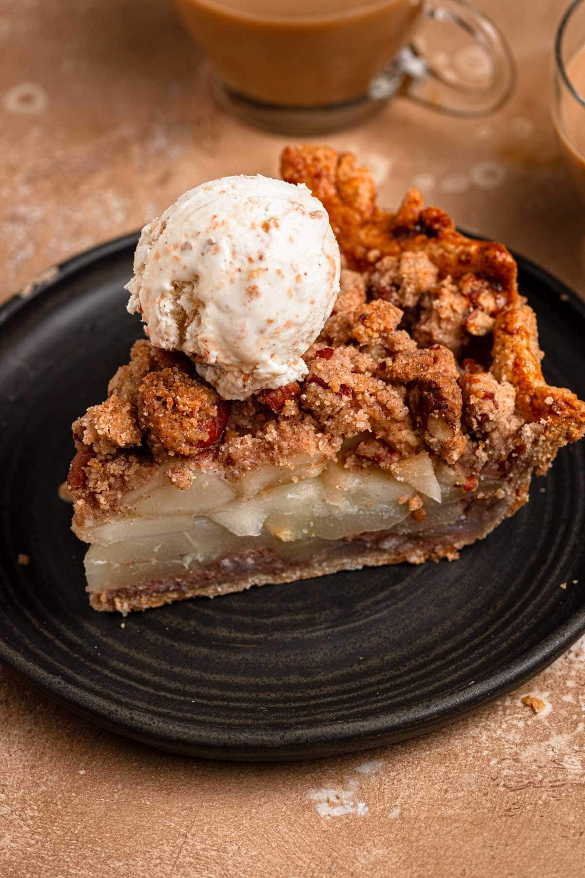 A pear pie slice topped with ice cream.
