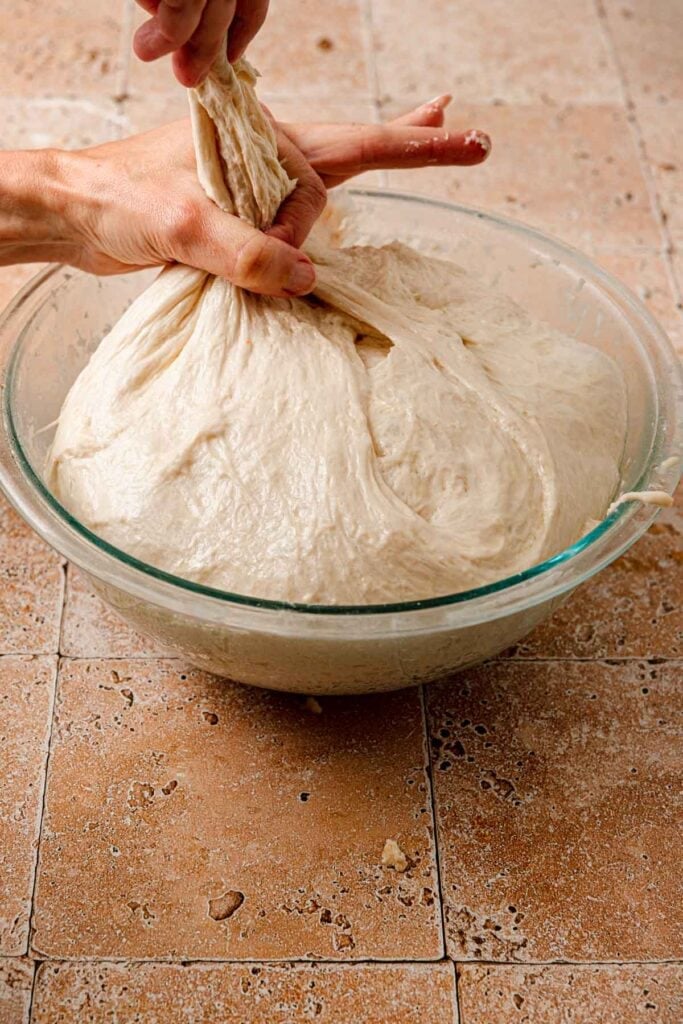 Hands pulling dough.