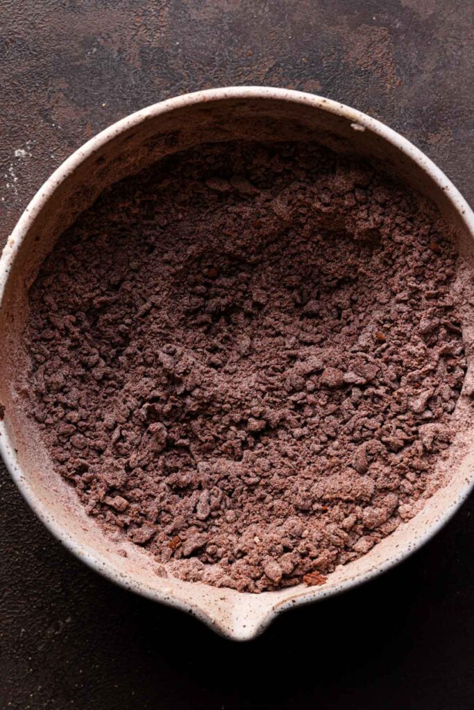 A bowl with crumbly chocolate and flour mixture.