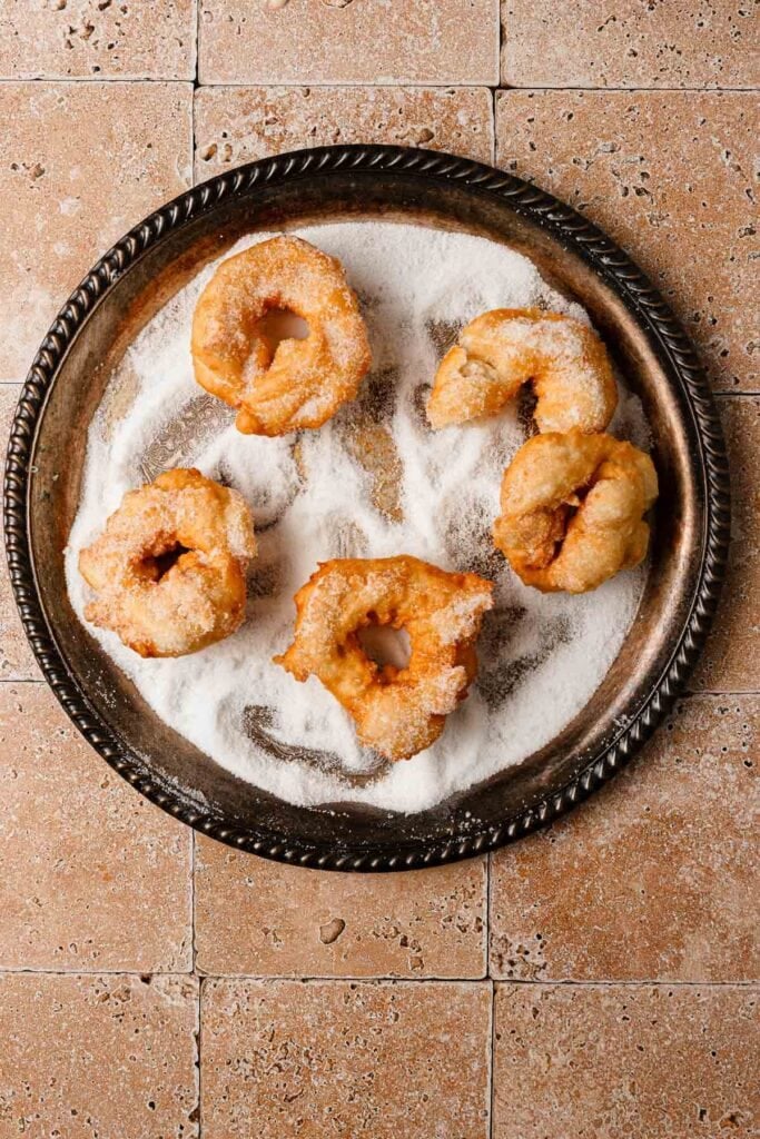 A large plate with sugar and moroccan donuts in it.
