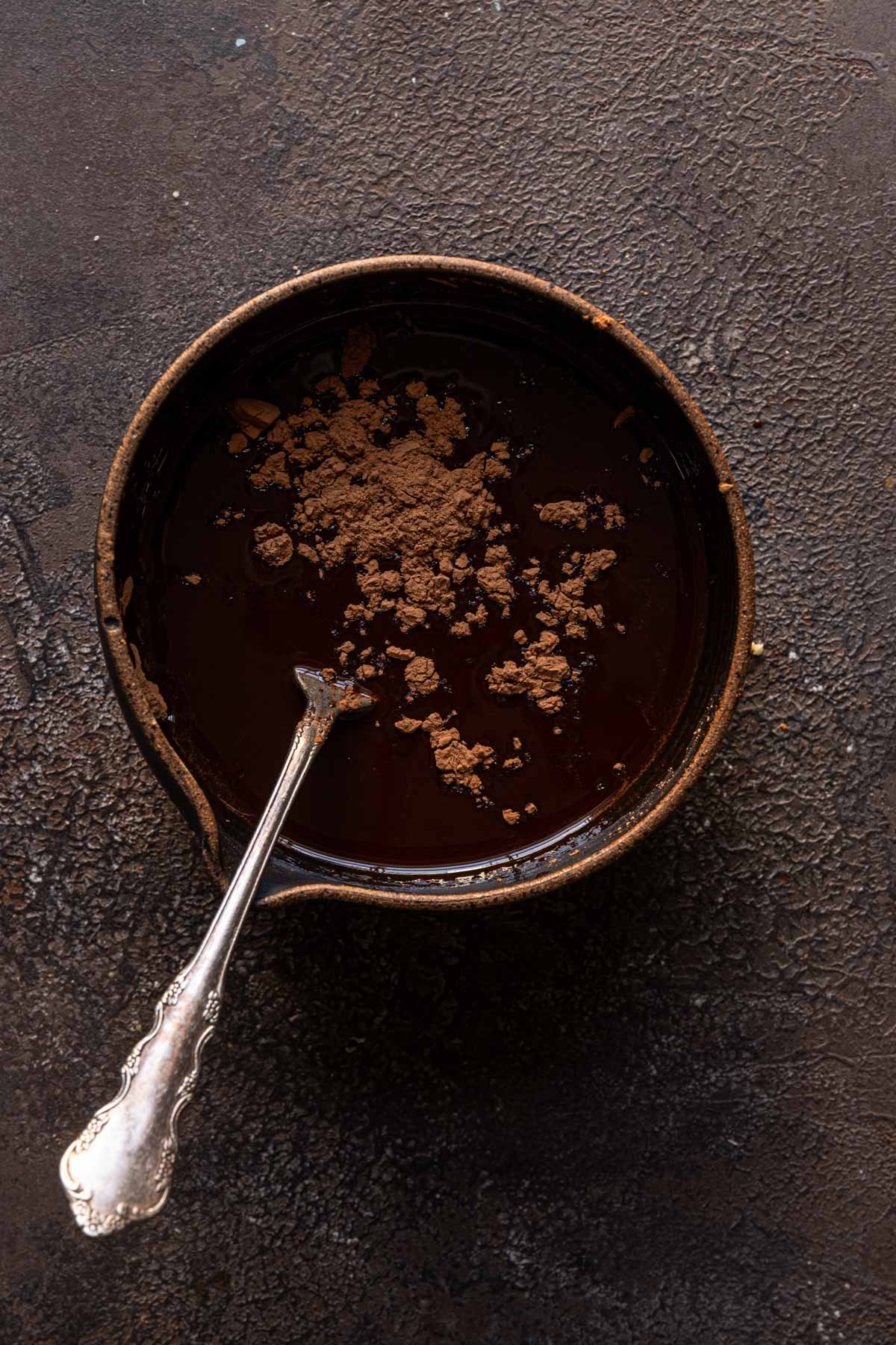 A bowl with olive oil and cocoa powder.