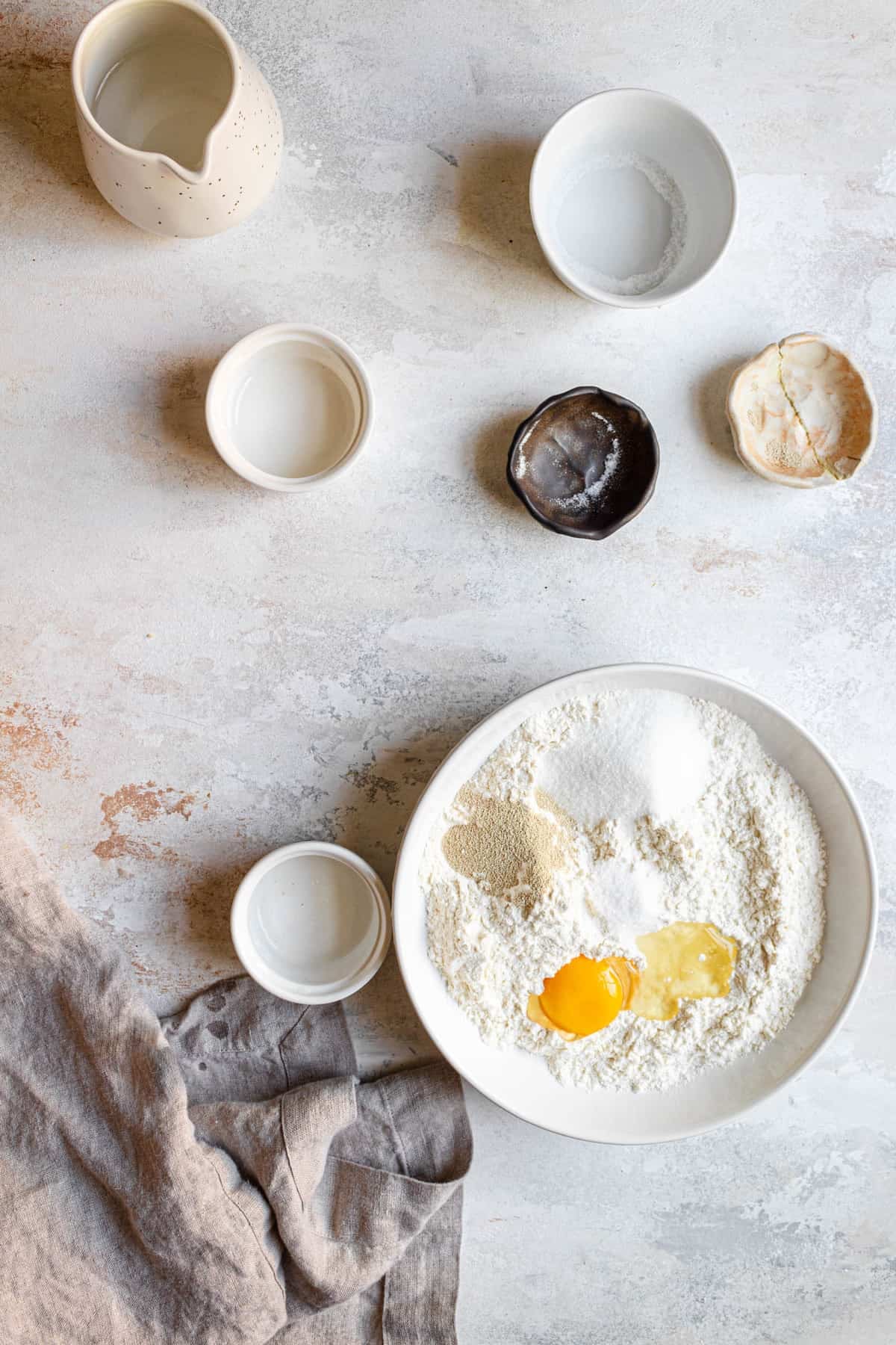A bowl with flour, sugar, yeast and an egg.