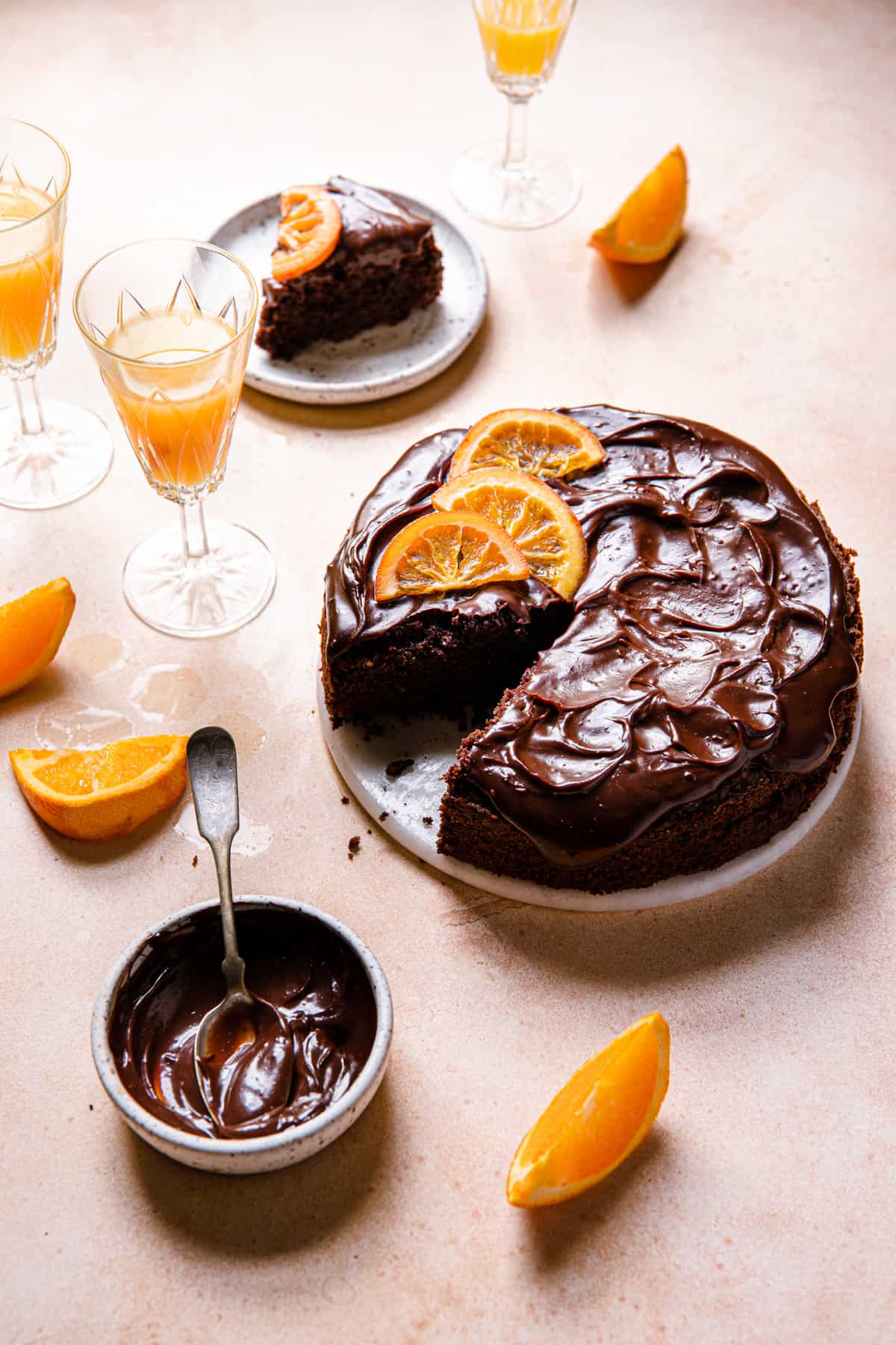 sliced cake topped with ganache and candied orange slices