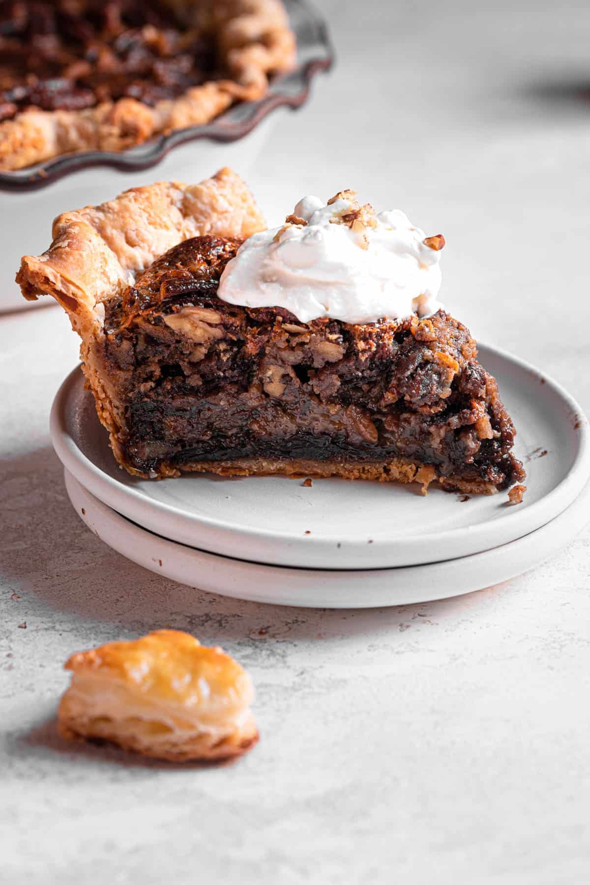 close up to a slice of pie topped with whipped cream