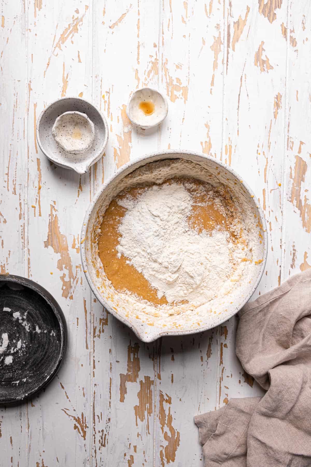 A large bowl with melted butter mixture and flour on top.