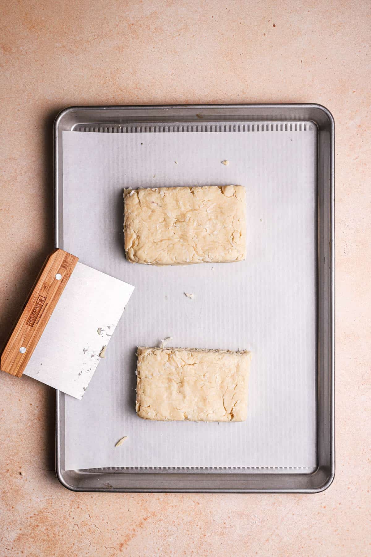 A large cookie pan with two rectangle scones dough.