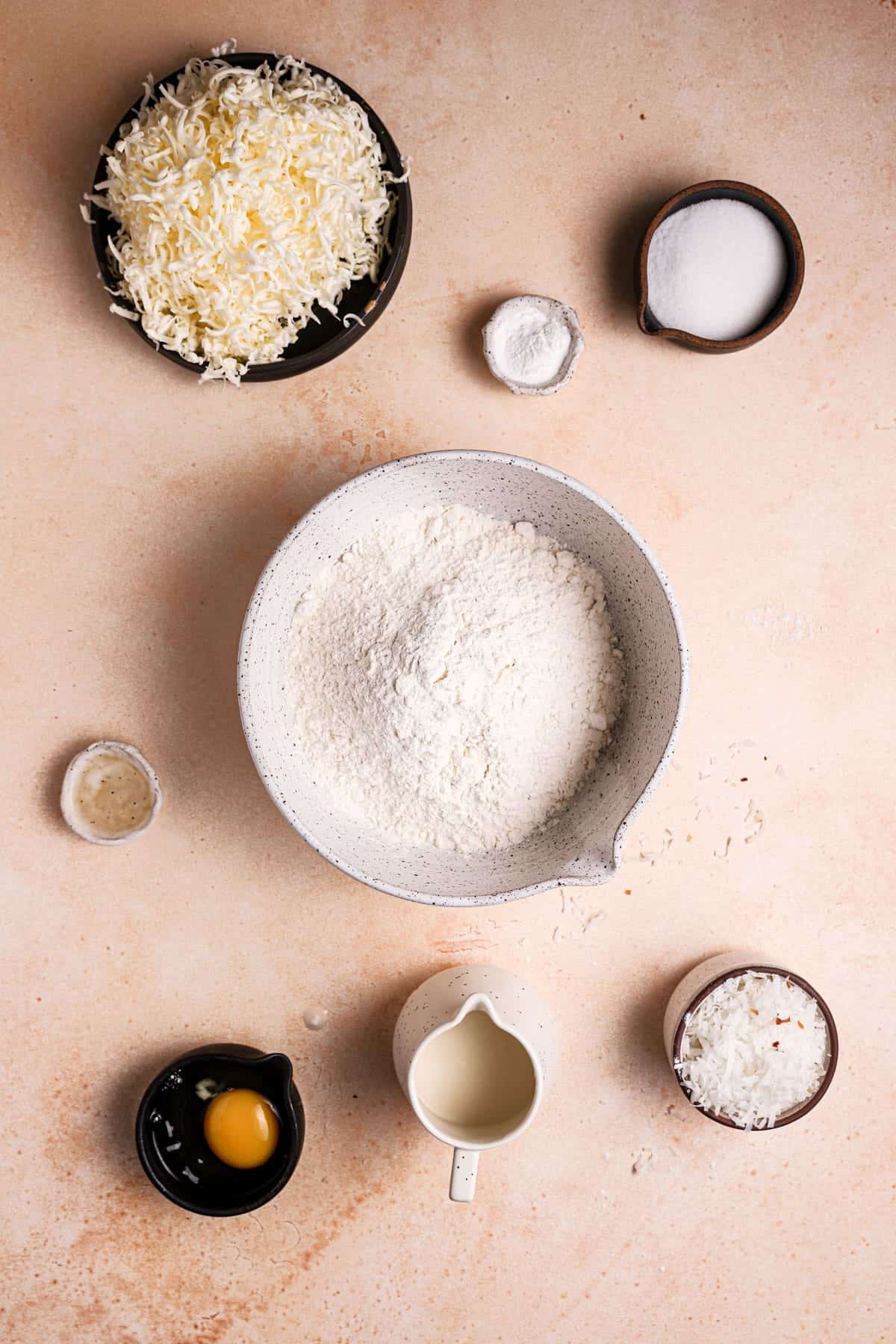 ingredients in bowls butter, flour, sugar, egg, coconut milk, shredded coconut