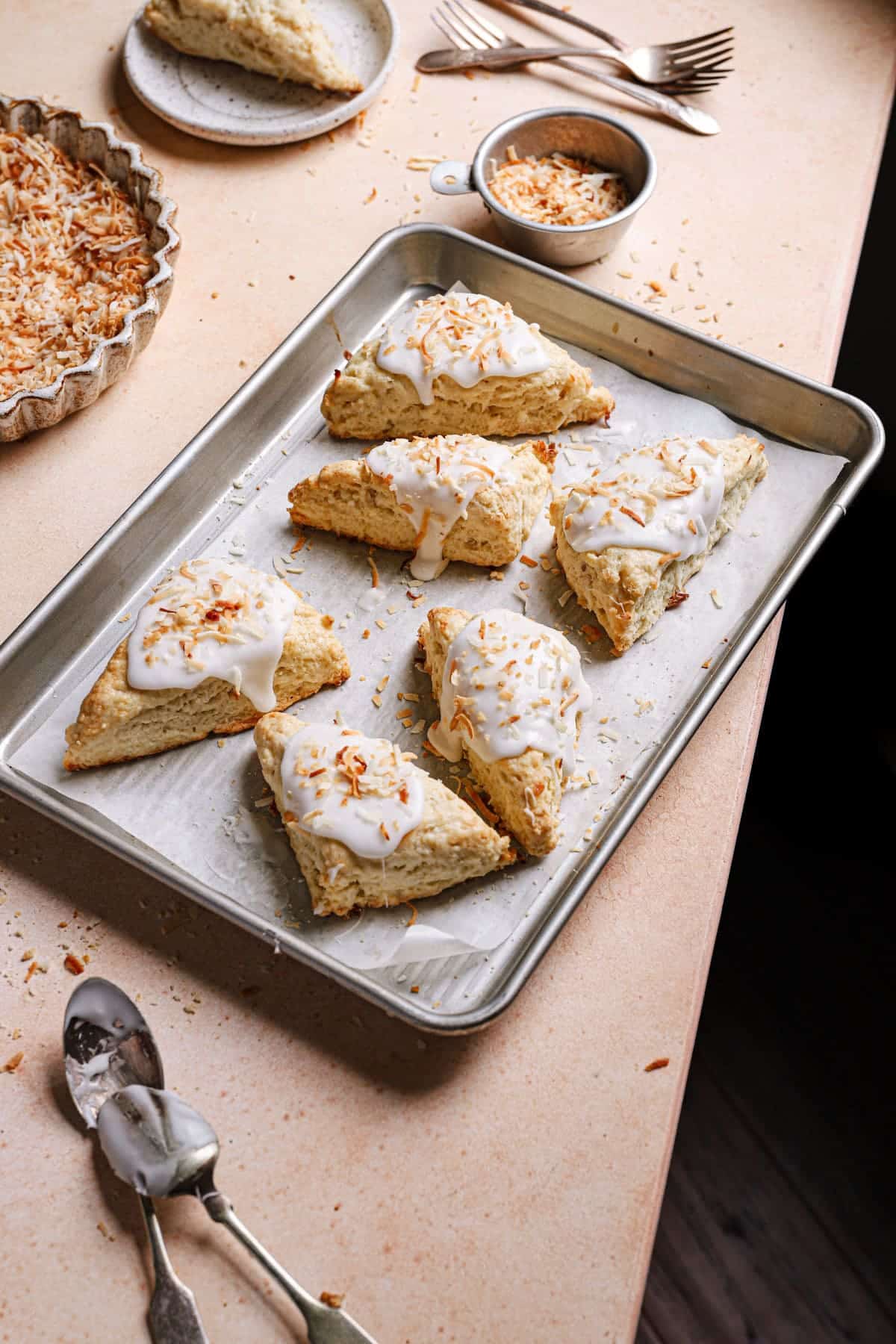 side view of  glazed scones topped with toasted coconut 