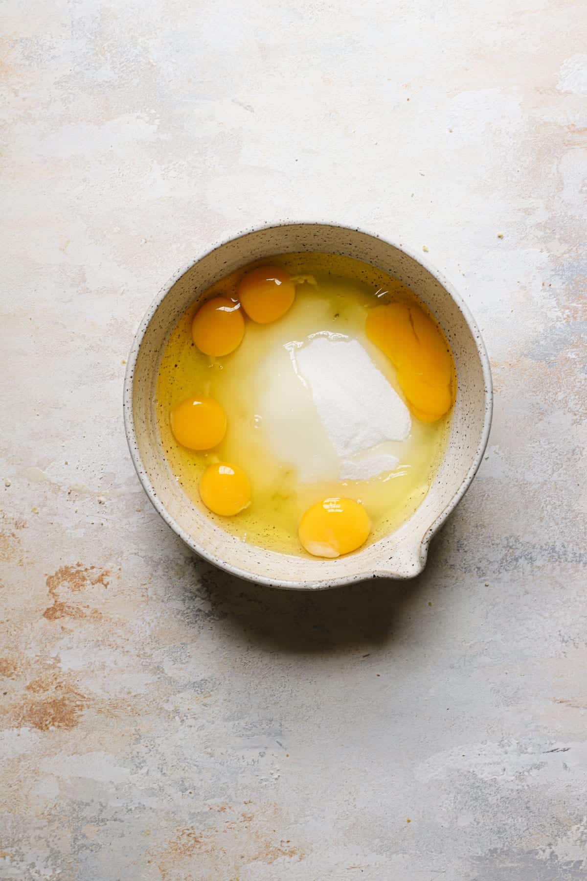 A mixing bow with eggs and sugar.