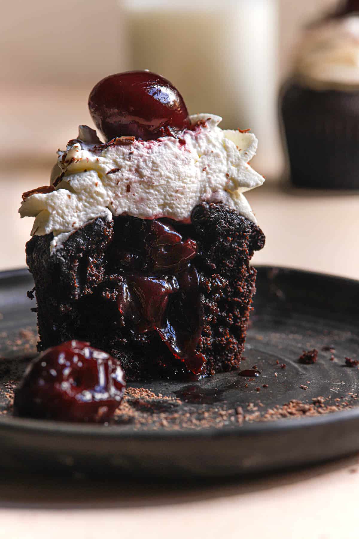 An inside look of a black forest cupcake filled with cherry filling.