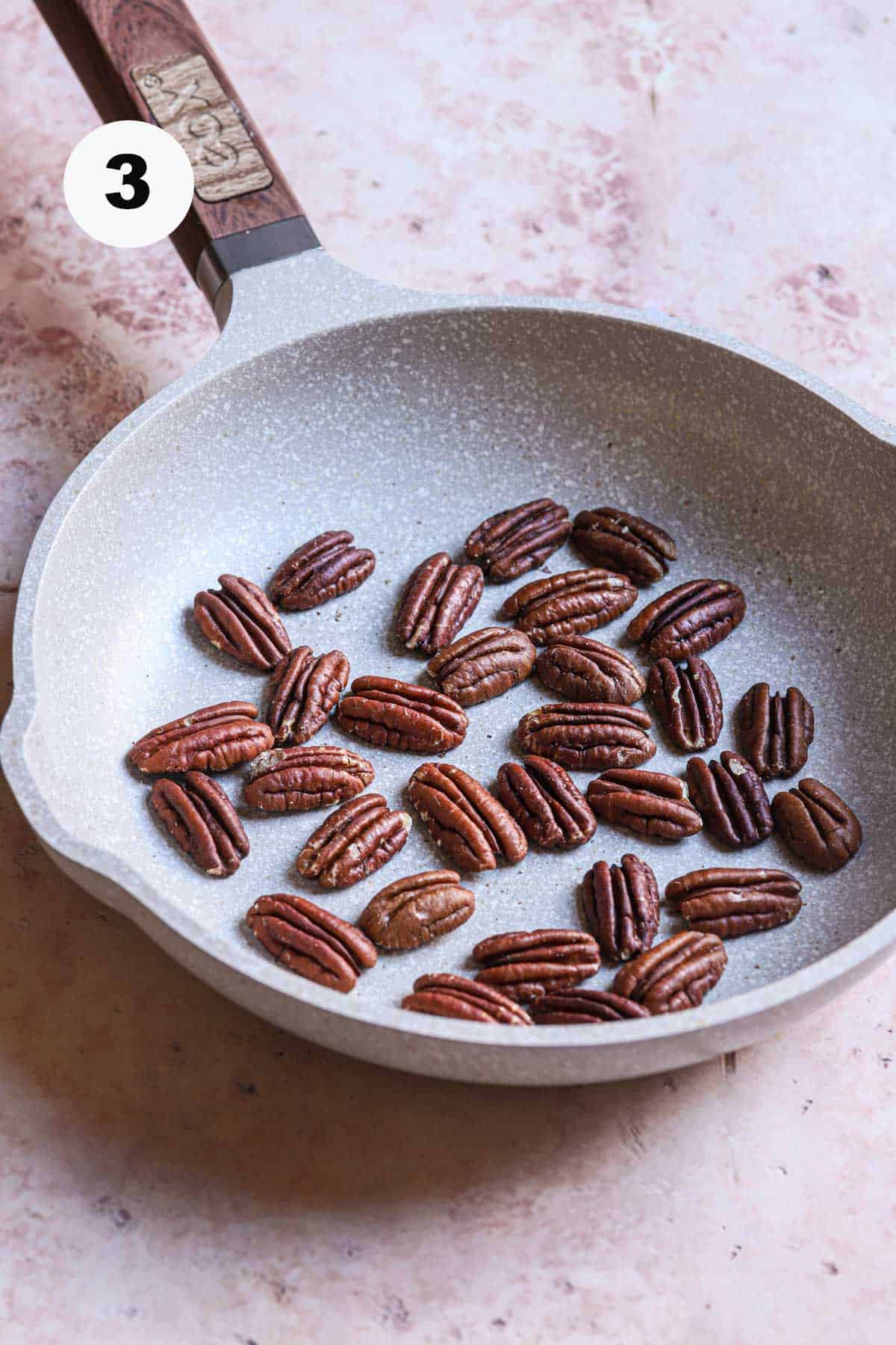 Toasted pecans in a skillet.