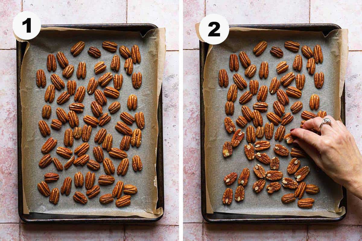 Pecans halves spread in a baking sheet, hand tossing.