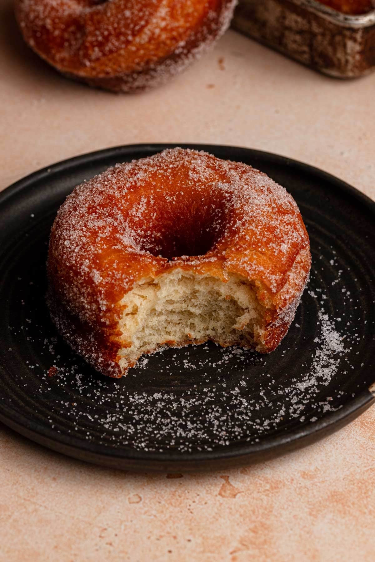 Brioche donut on a plated coated with sugar.