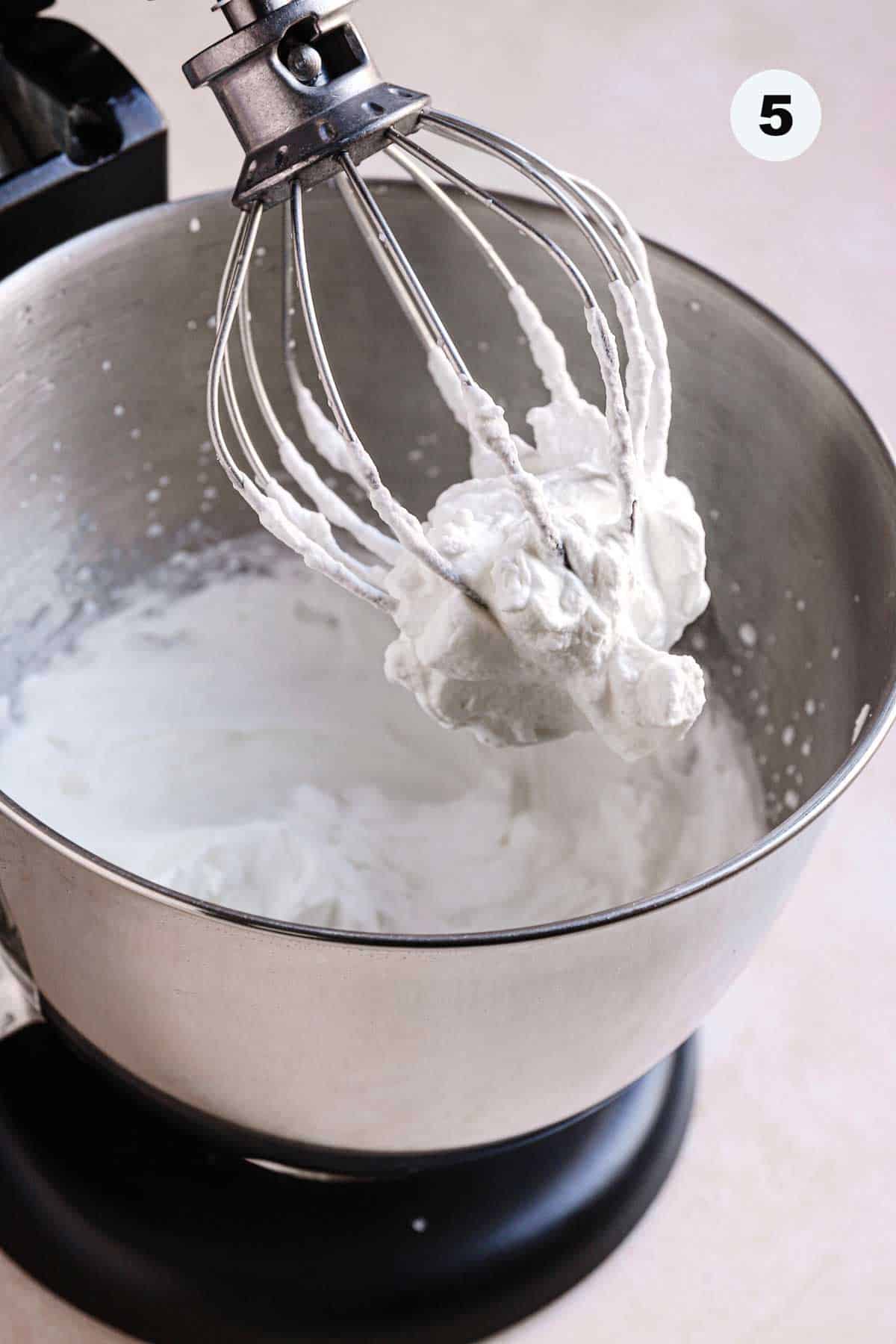 A whisk attachment full with stabilized whipped cream.