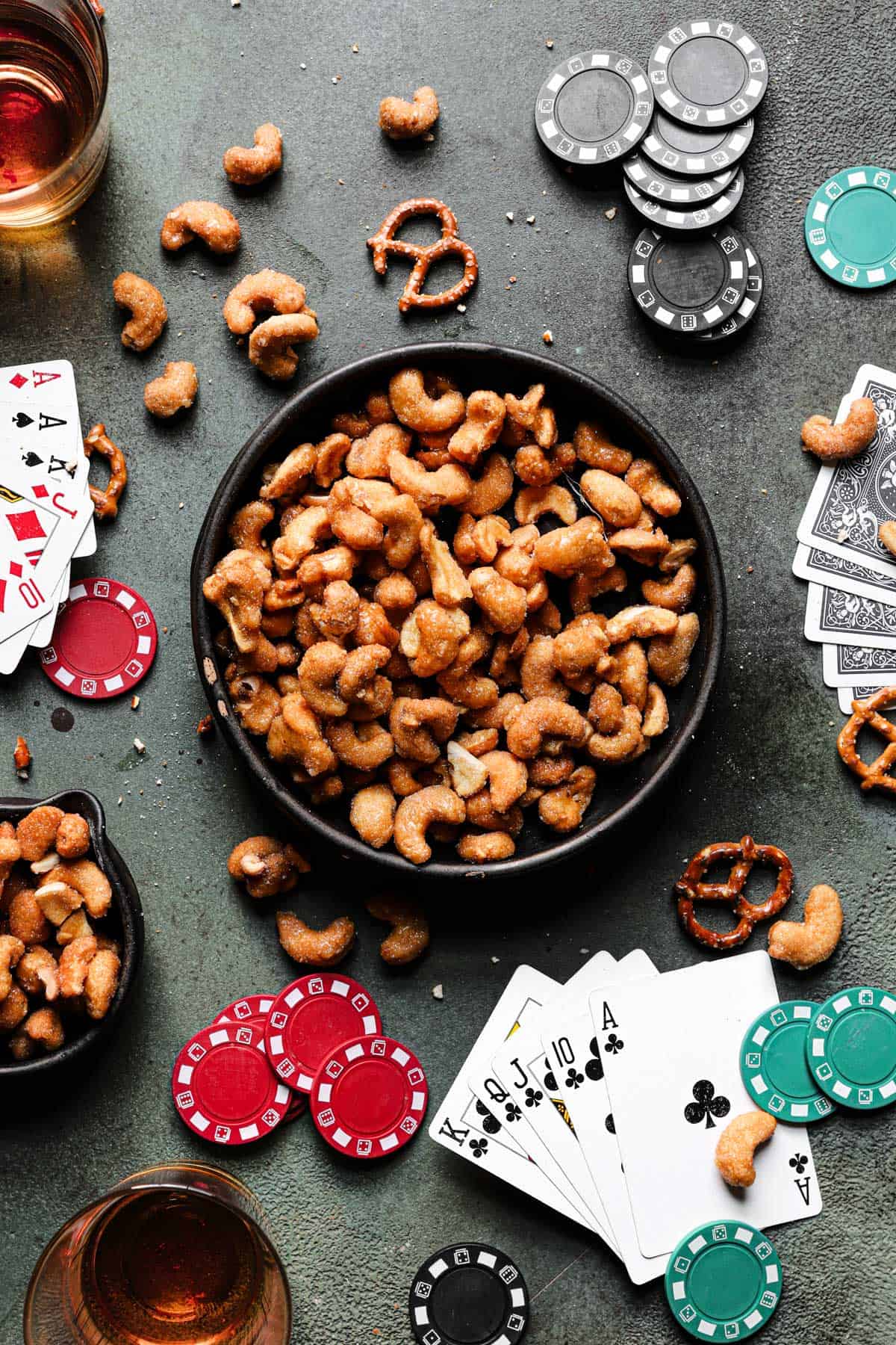a poker table with a bowl of roasted cashews coated with honey at the center.
