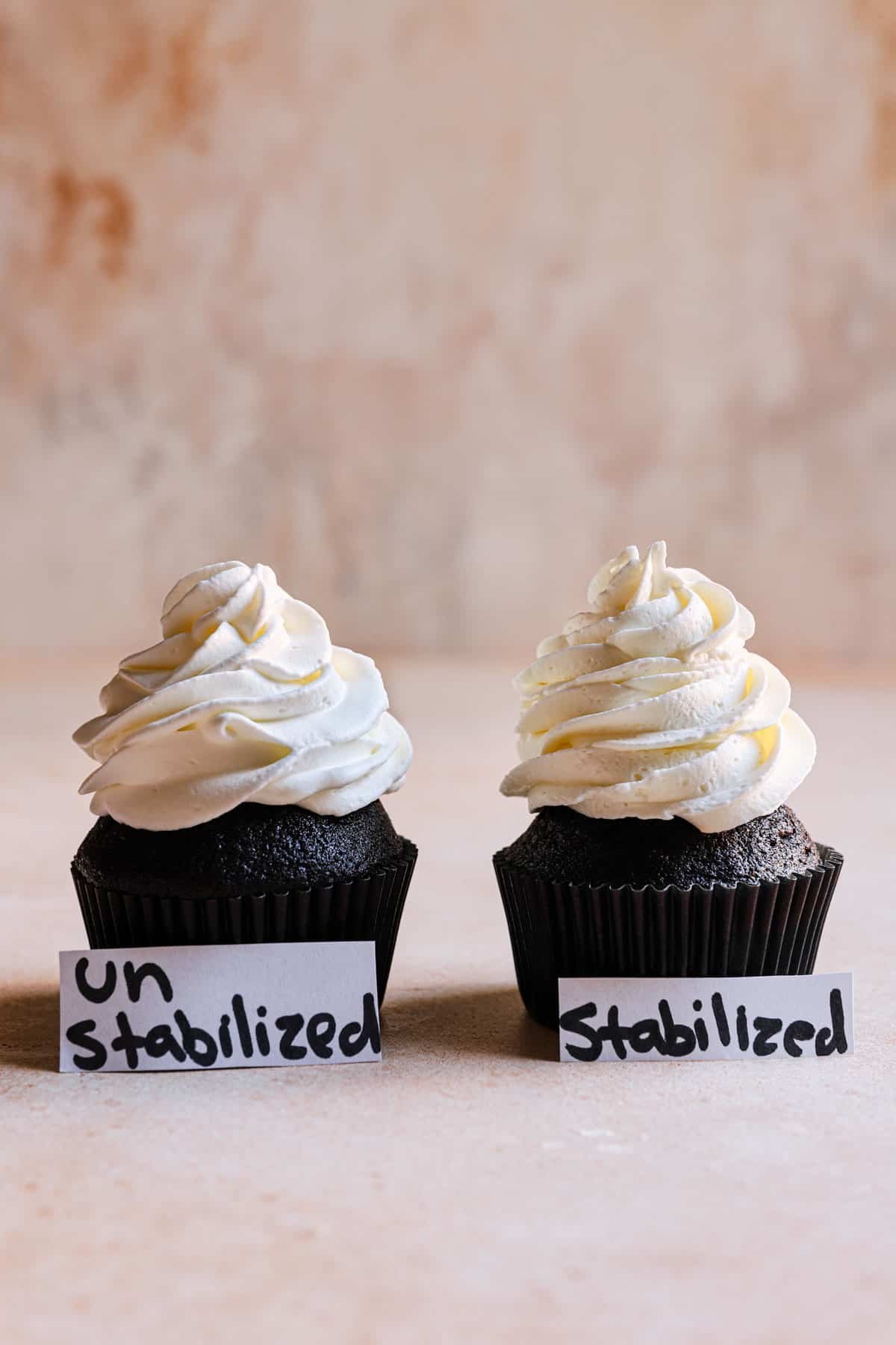 two cupcakes with stabilized and un stabilized heavy cream.