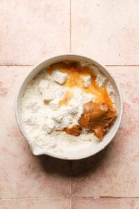 a bowl with flour, butter, cookie butter and an egg