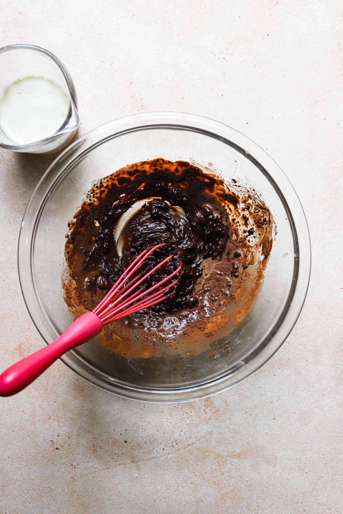 A bowl with cocoa mixture and a whisk.