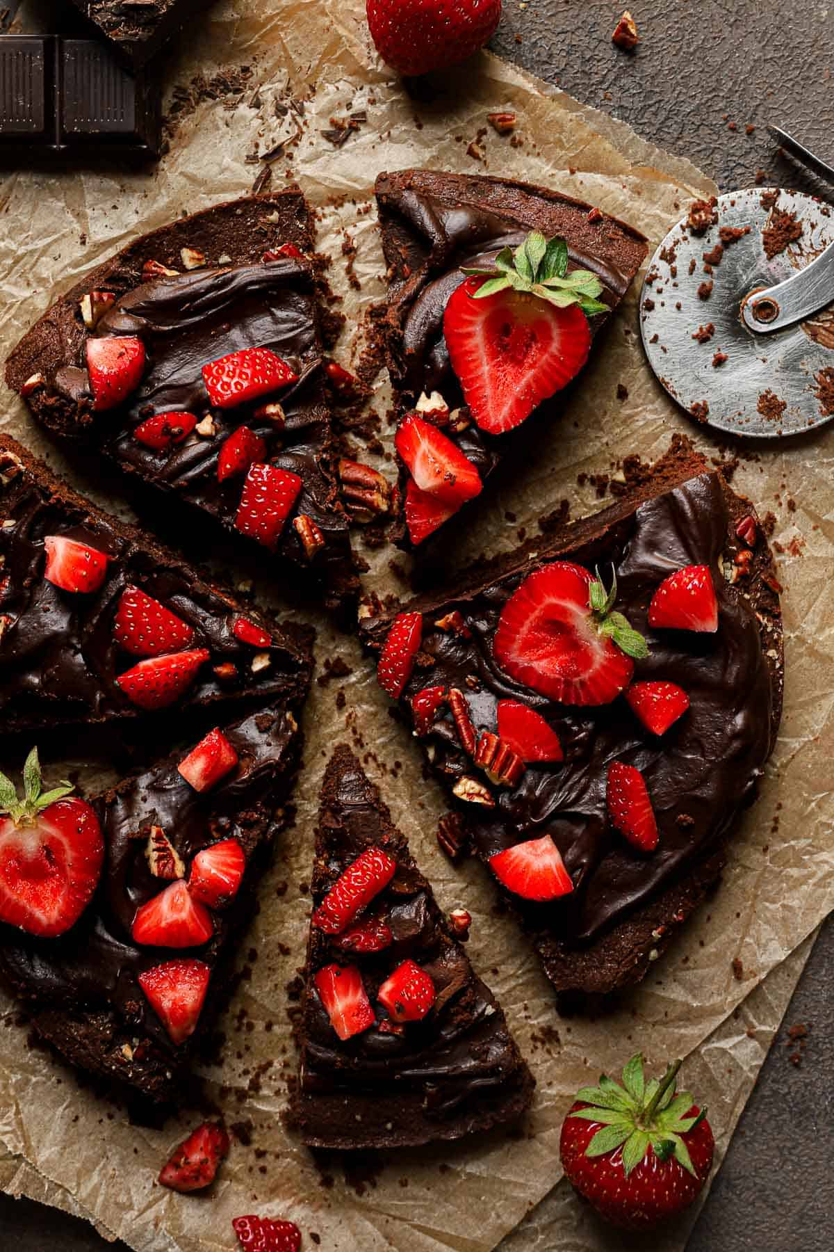 brownie pizza topped with ganache and strawberries
