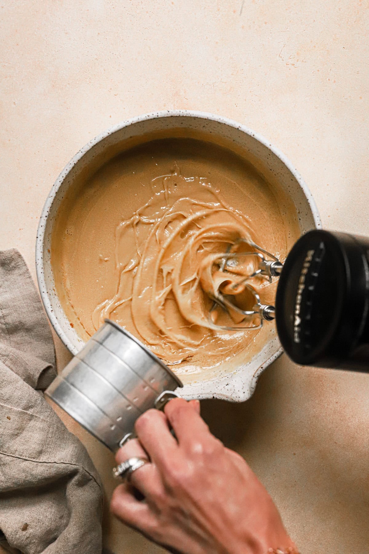 Pouring oil into a cake batter.