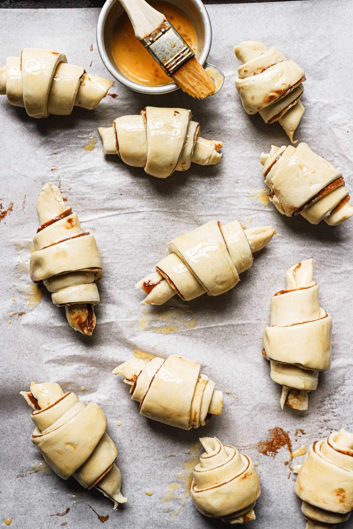 Unbaked Nutella croissant brushed with an egg wash.