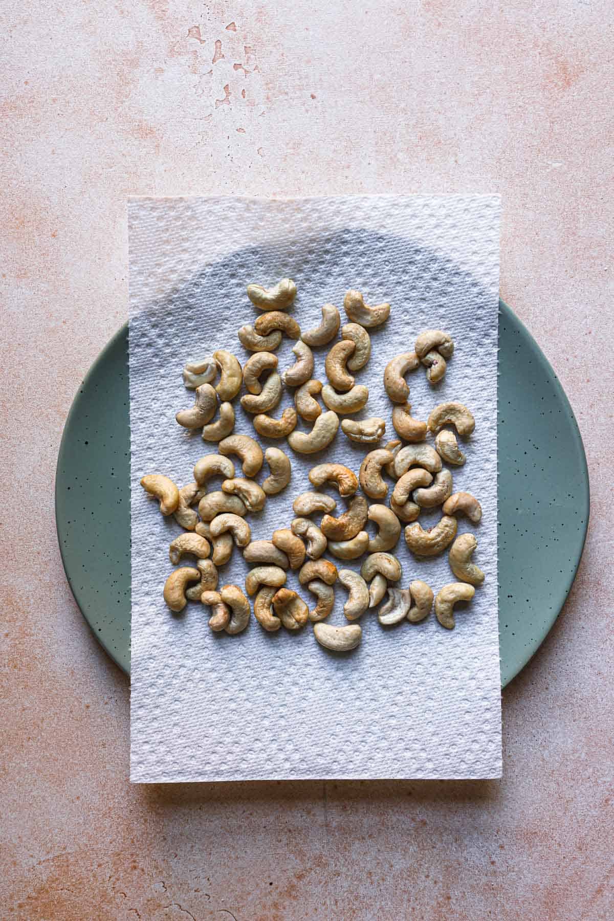 Cashews in a plate over a paper towel.
