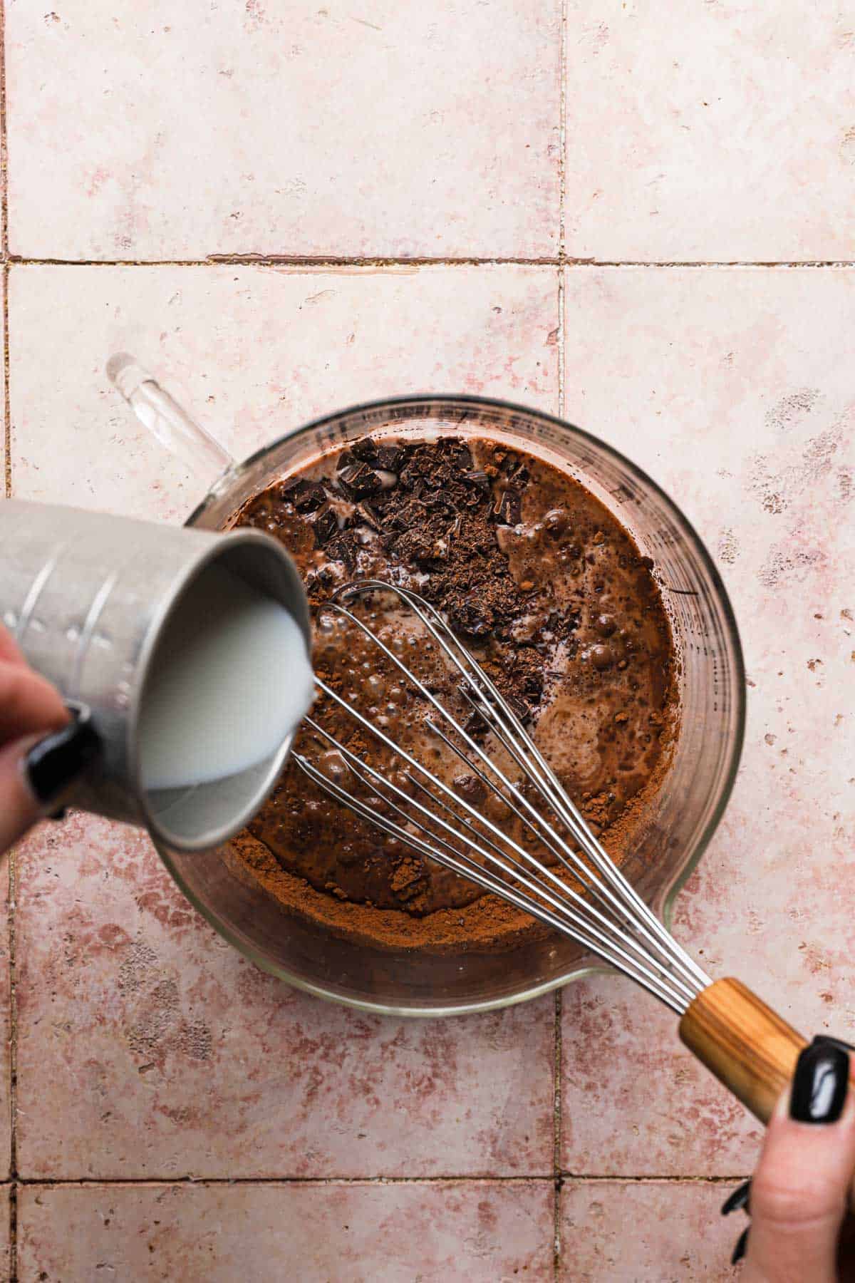 pouring milk over cocoa powder