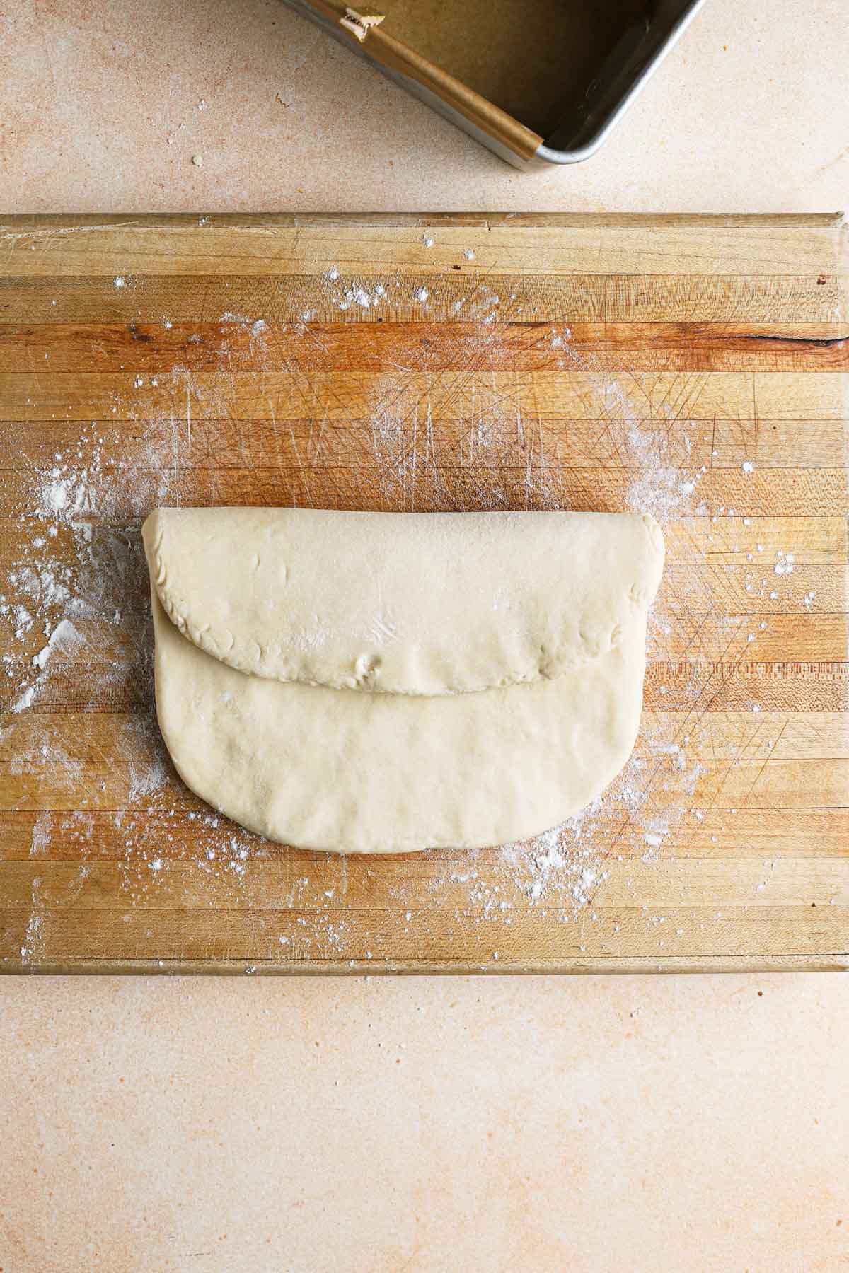 Brioche dough shaped into a square, top part folded towards the middle.