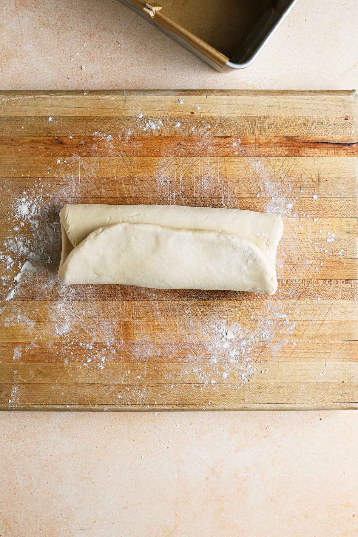 Brioche dough shaped into a square. folded into three.