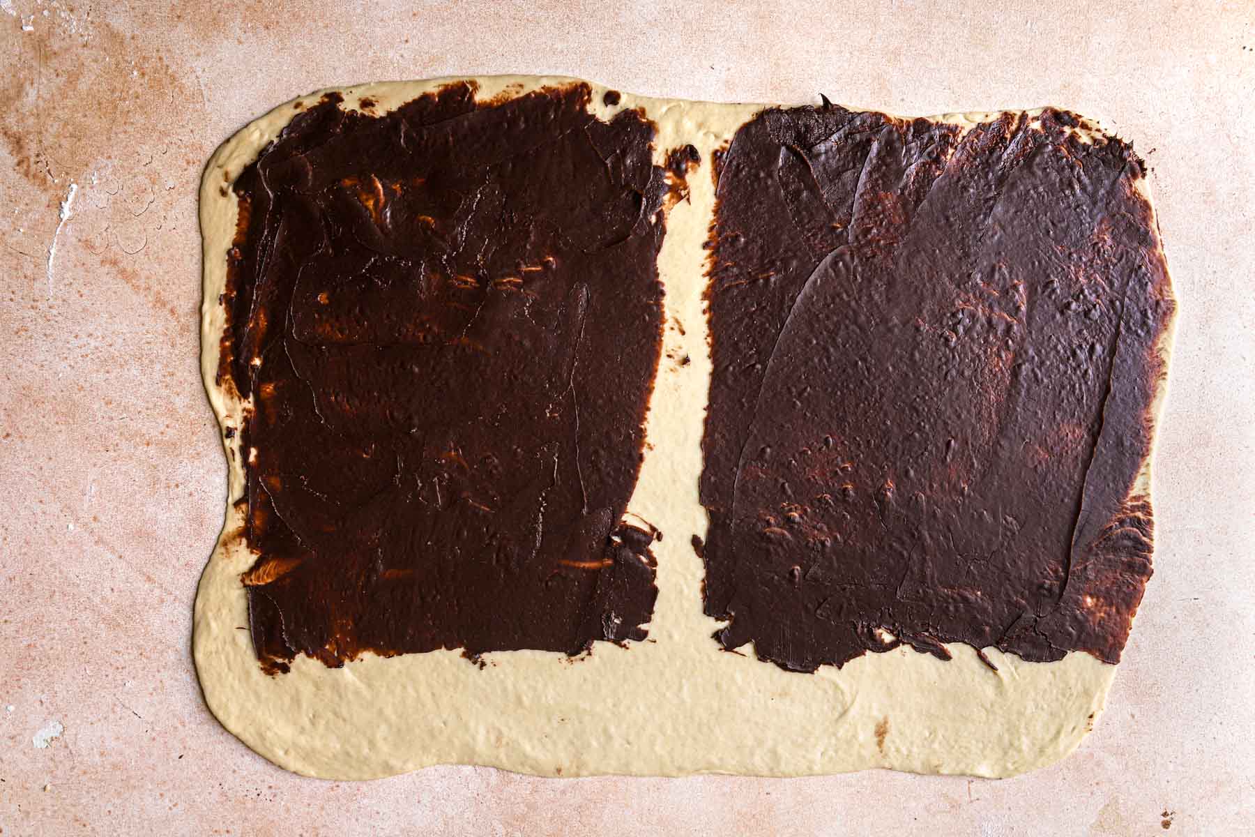 A rectangle dough topped with chocolate filling.