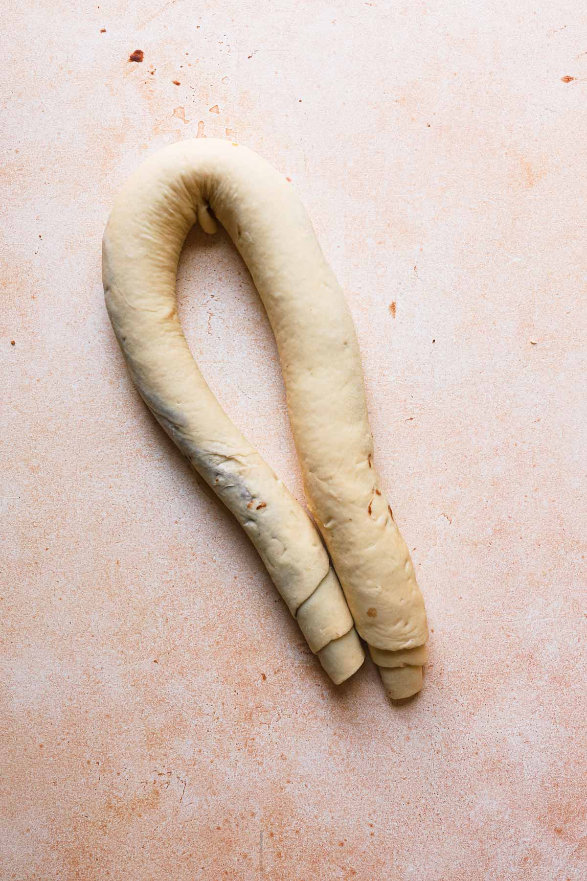 A log of filled dough shaped into a U.