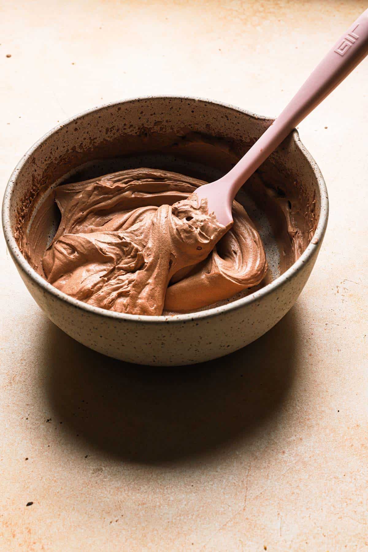 chocolate whipped cream in a bowl with a spatula
