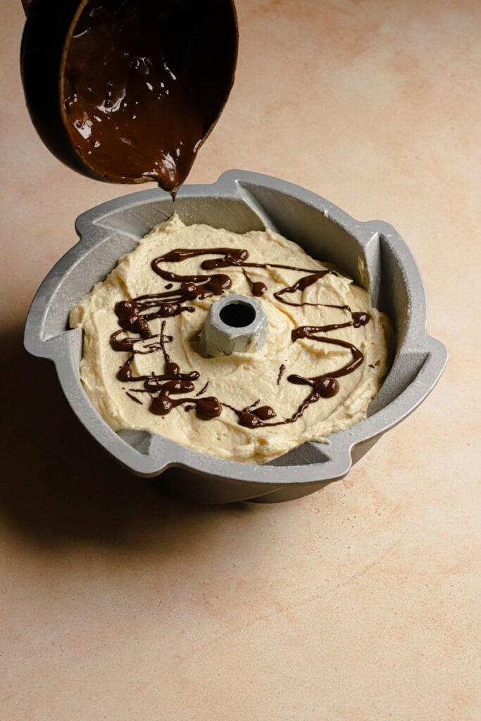 Drizzling melted chocolate over unbaked cake batter.