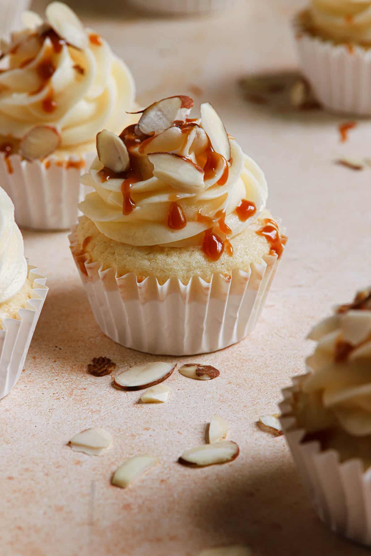 a cupcake topped with caramel and sliced almonds