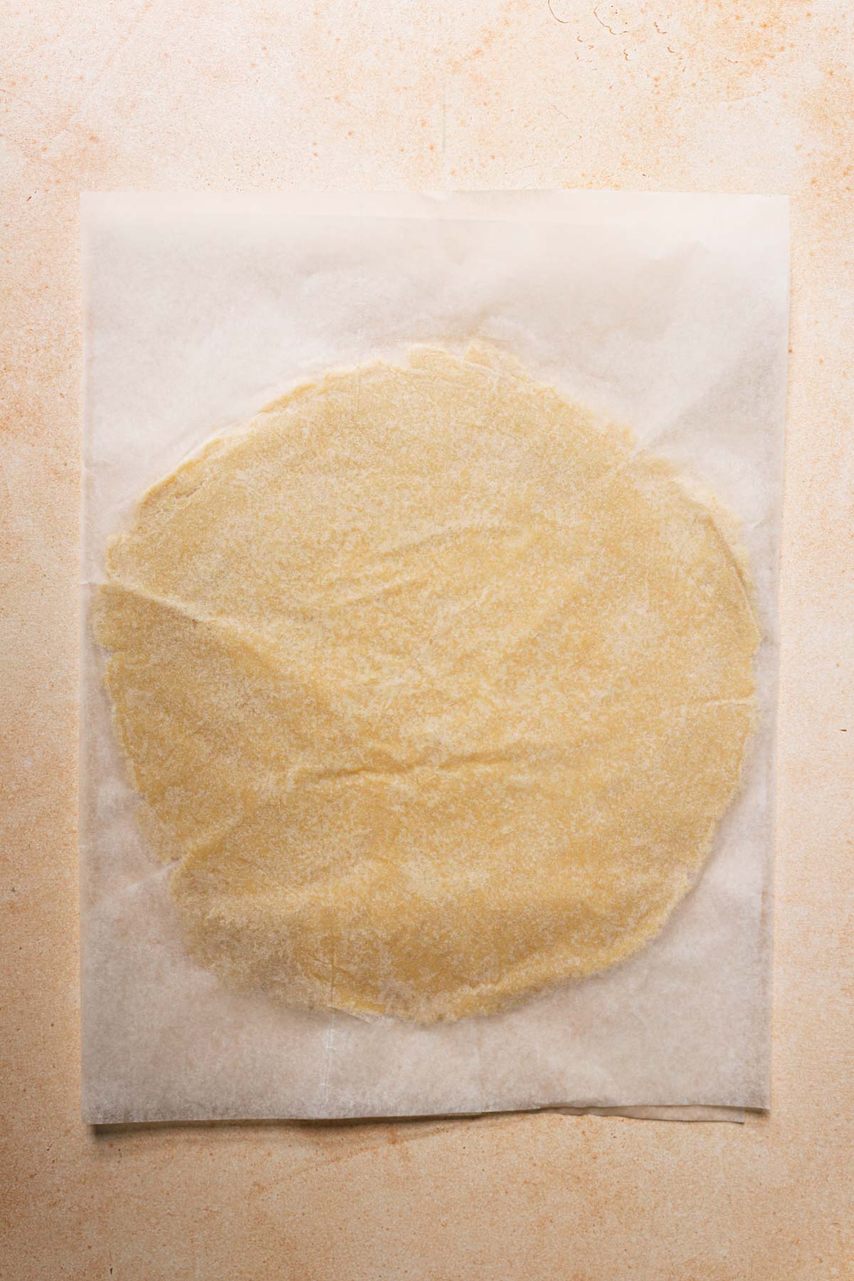 Dough roled between two peices of parchment paper.