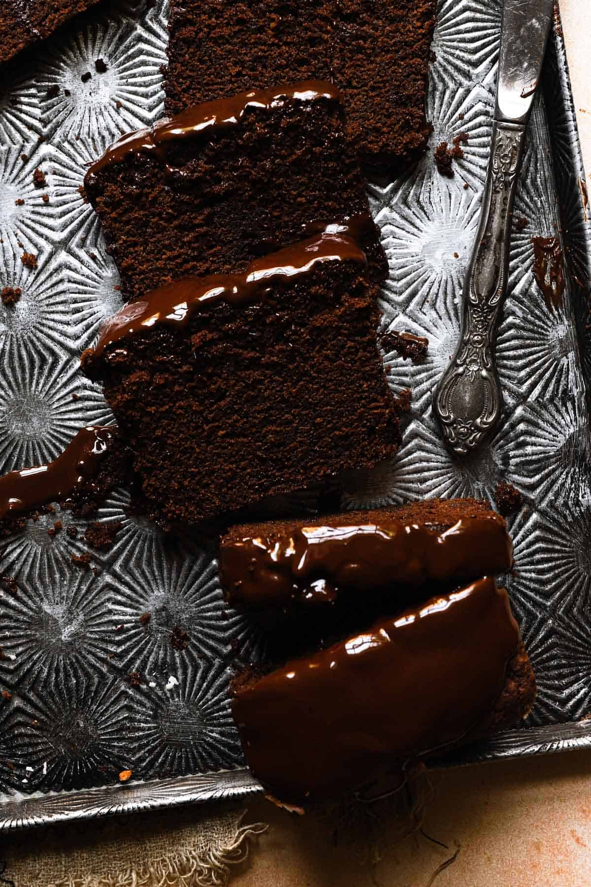 Sliced chocolate cake on a tray with a knife