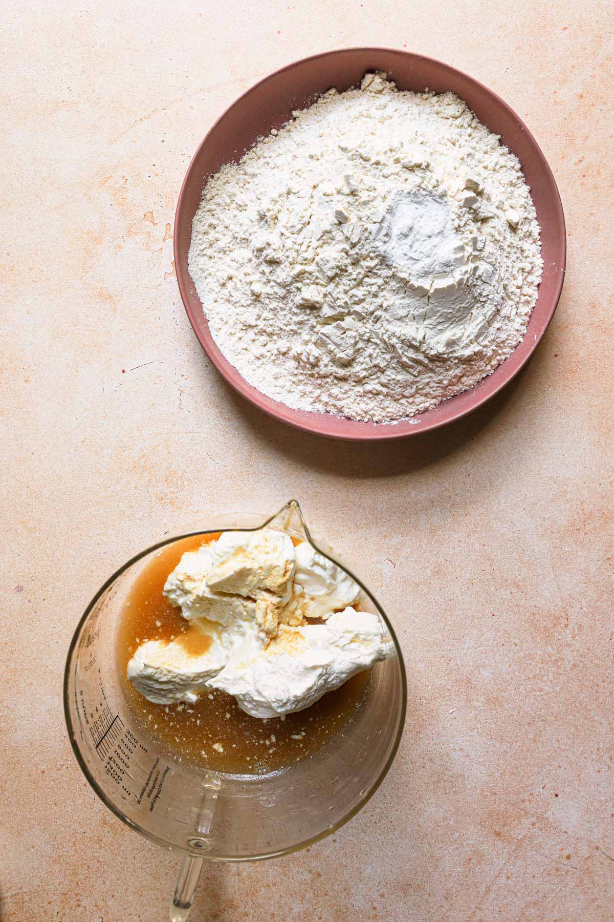 A bowl with flour and another bowl with sour cream and lemon juice.