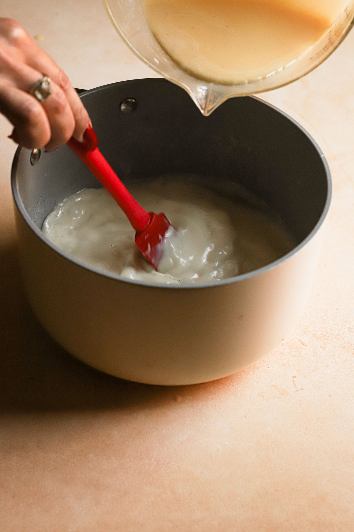 Pouring egg mixture to a pot while stirring.