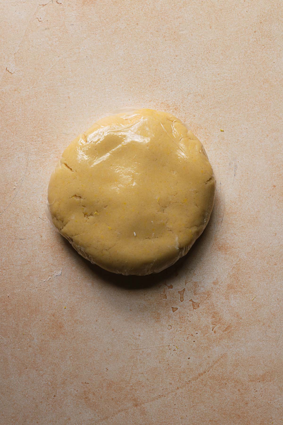 Pasta frolla dough wrapped with plastic wrap.