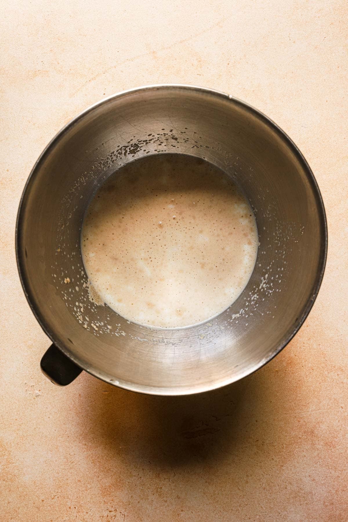 A mixing bowl with milk and yeast.