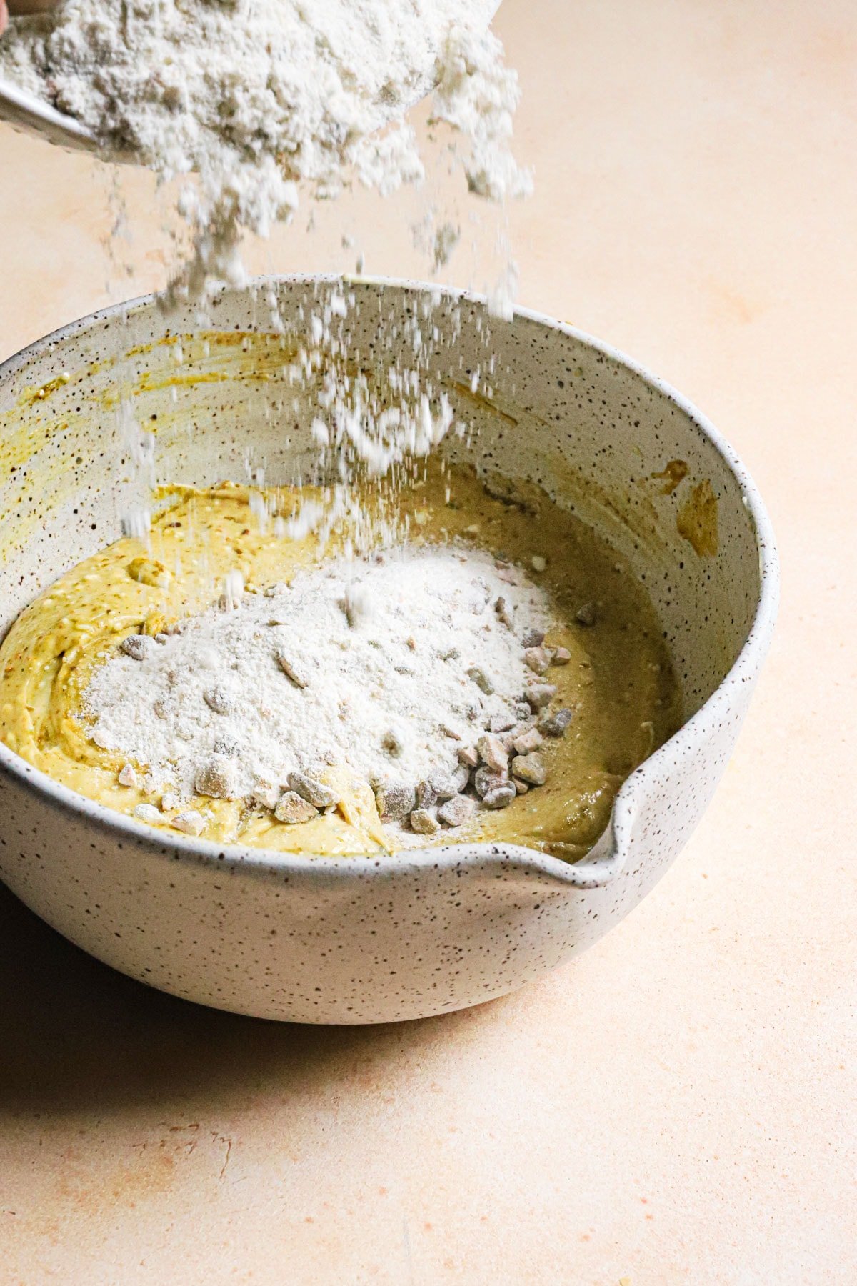 Adding flour to a bowl.