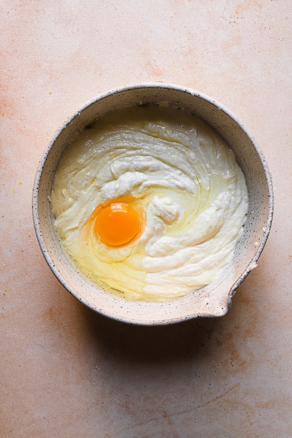 A bowl with creamed butter and a whole egg.