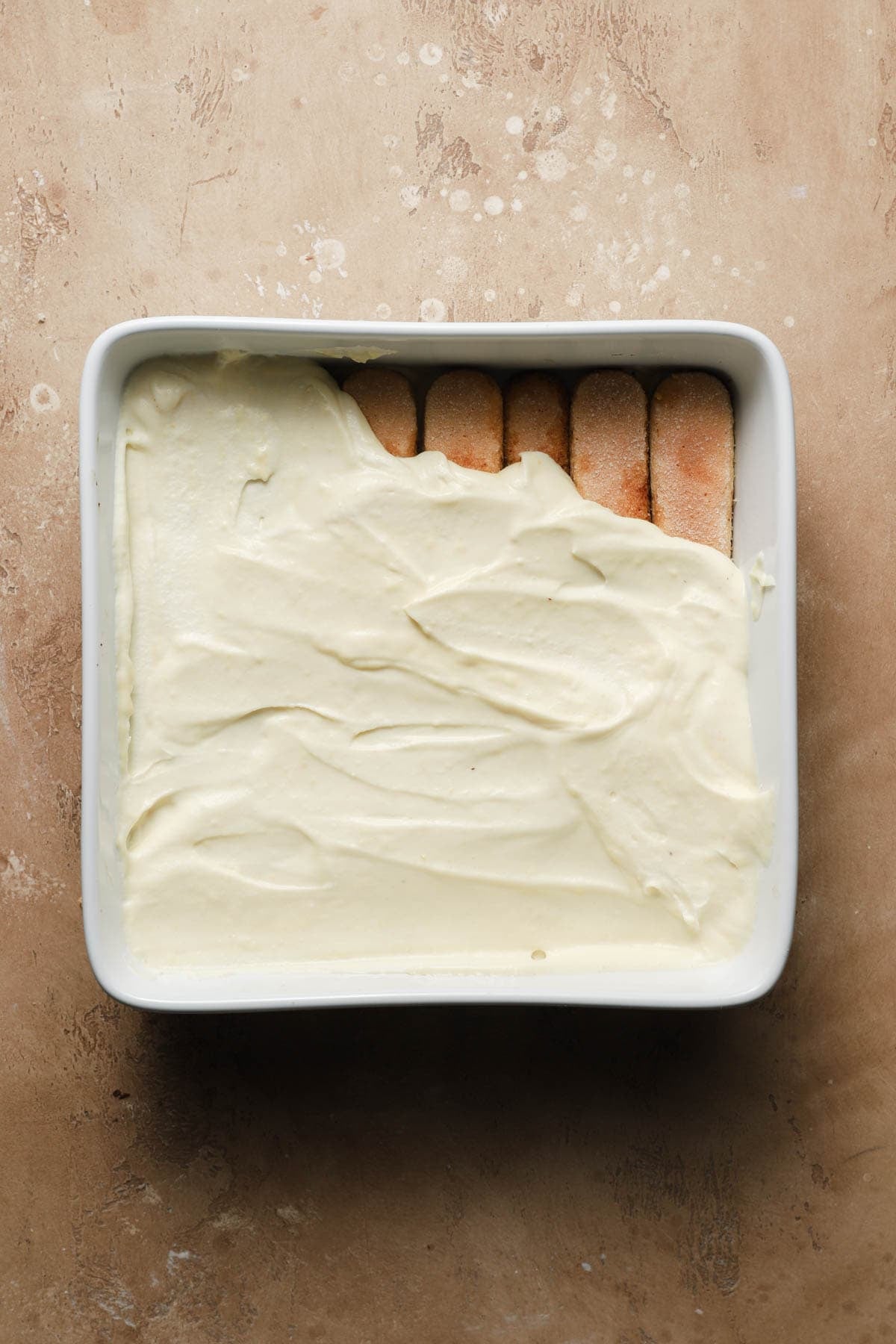 A dish layered with ladyfingers topped with cream.