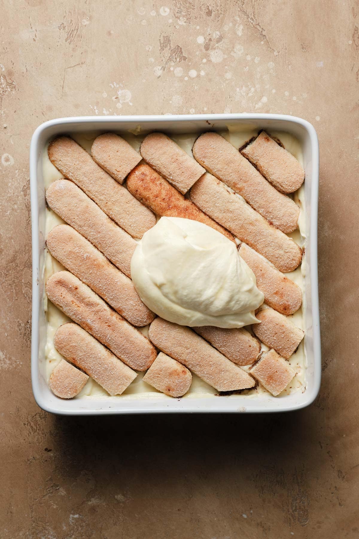 A dish layered with ladyfingers topped with cream.
