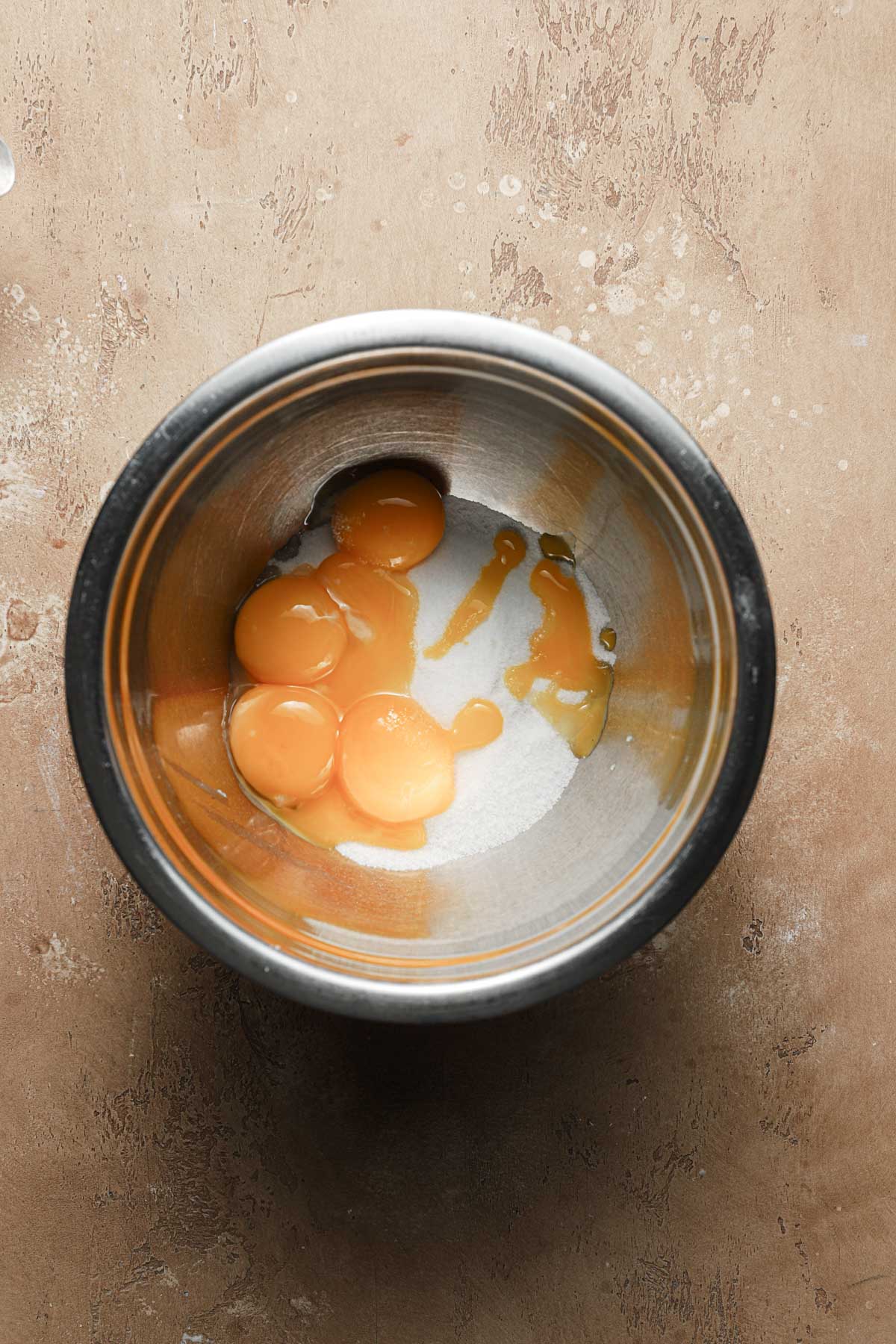 A large bowl with egg yolks and sugar.